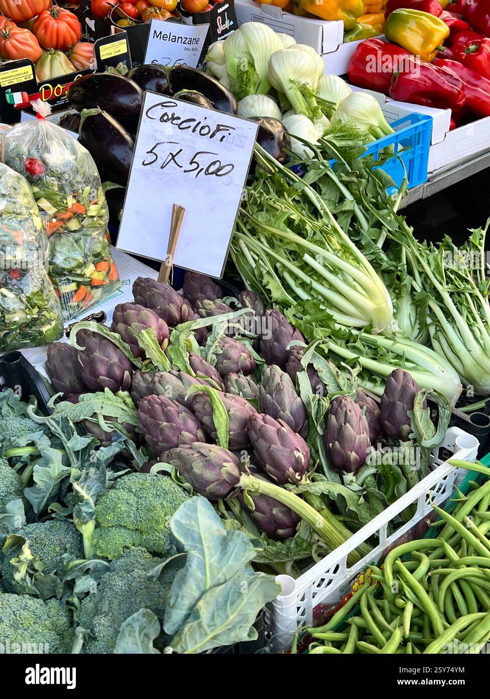 Una vivace esposizione di carciofi freschi, broccoli, peperoni e molto altro ancora in un mercato agricolo. - Immagine stock catturata con smartphone