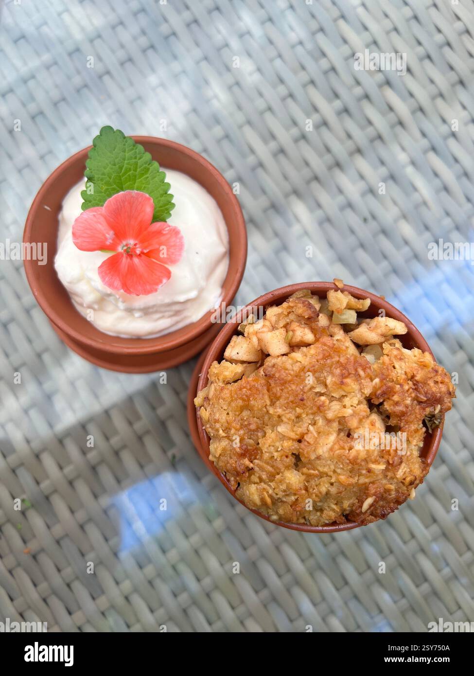 Dolce alla mela e panna fatto in casa guarnito con menta fresca e fiori Foto Stock