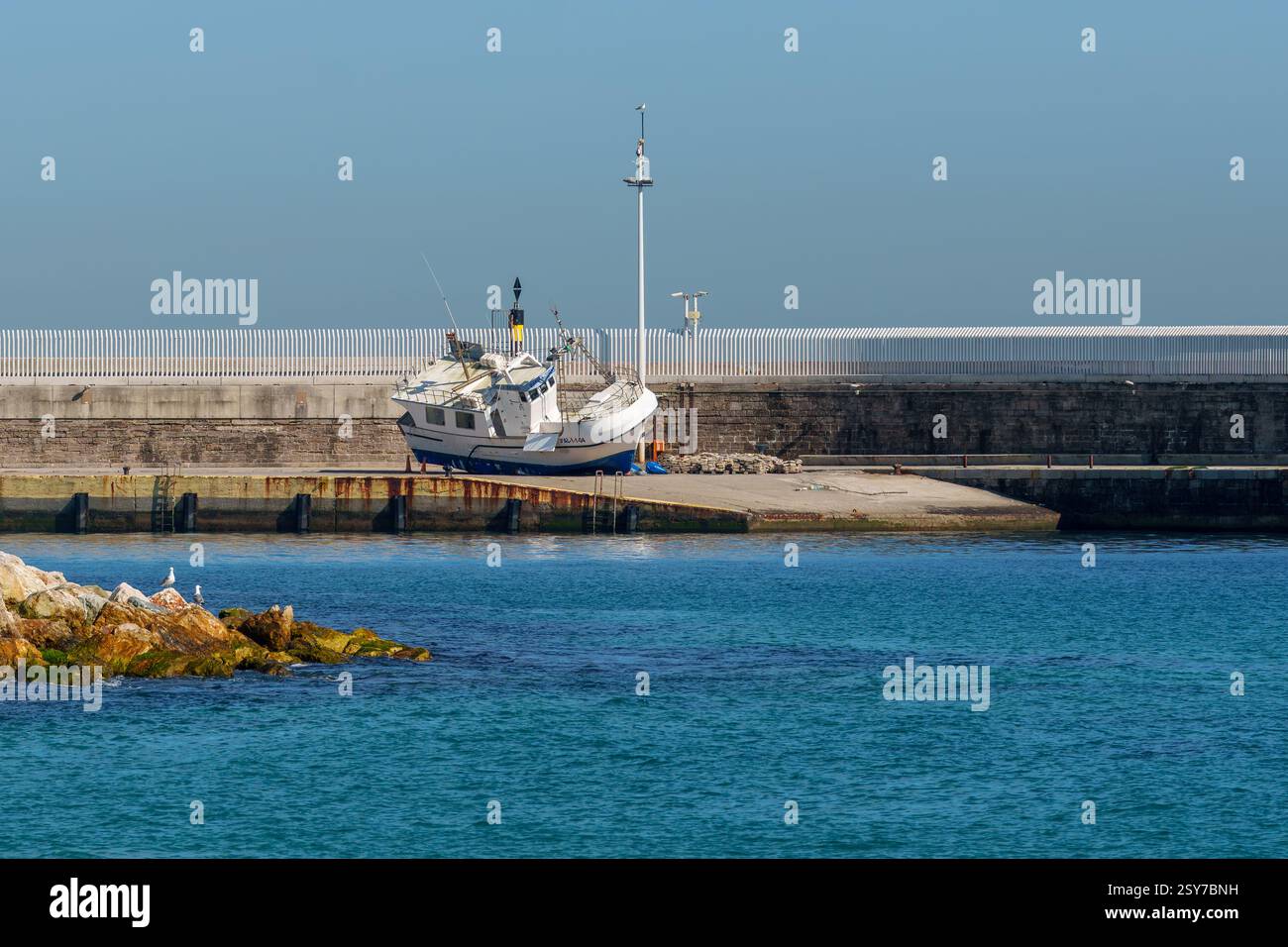 Una barca si trova sul molo, accanto alla rampa Foto Stock