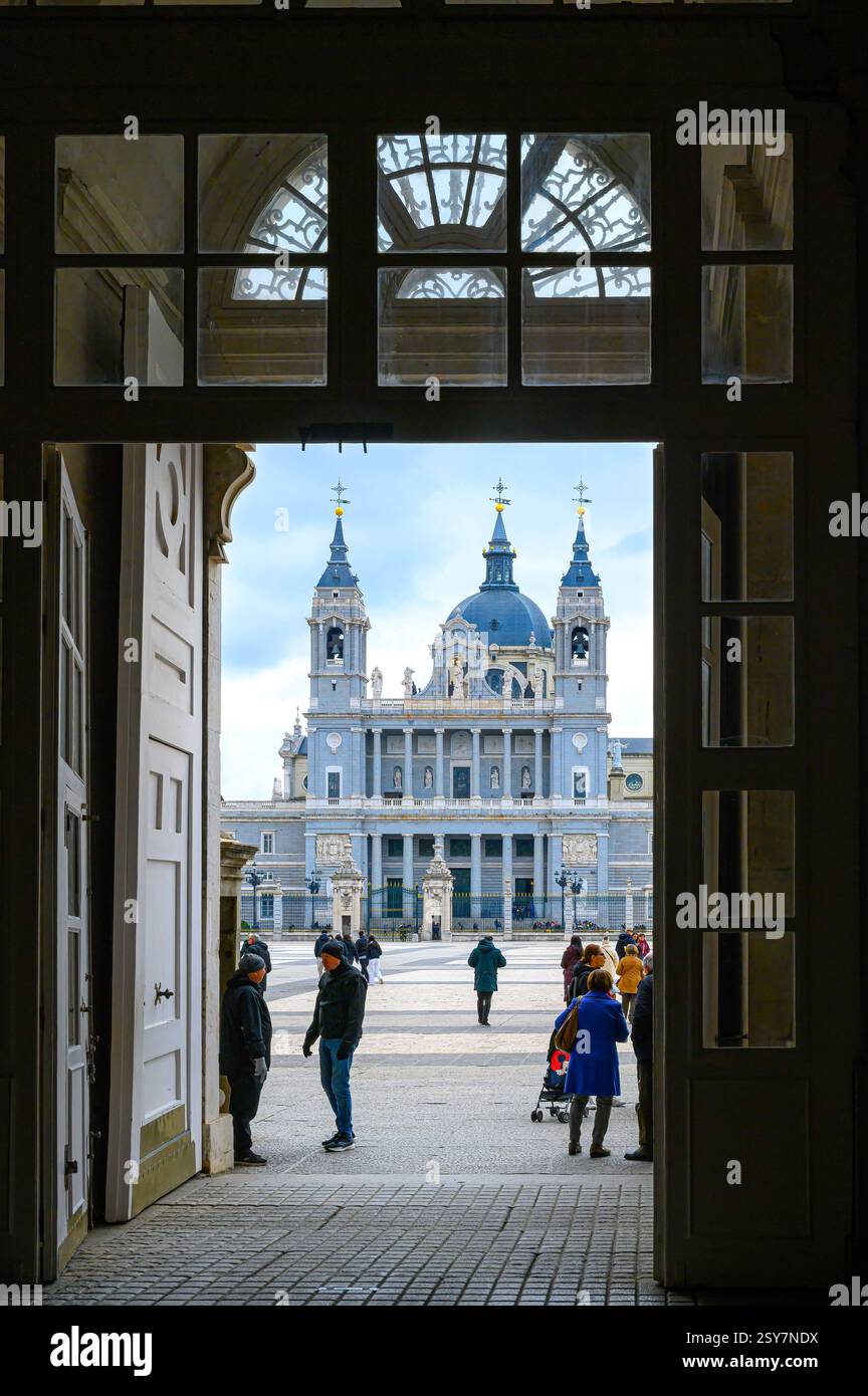 Persone all'ingresso del Palazzo reale, la Cattedrale di Almudena in lontananza, Madrid, Spagna Foto Stock