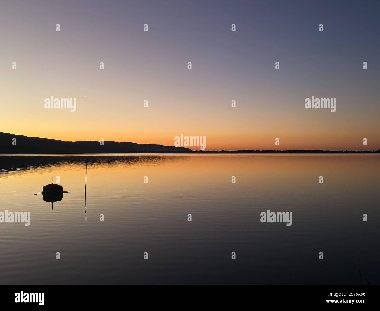 Riflessioni dorate della laguna di Orbetello al tramonto Foto Stock