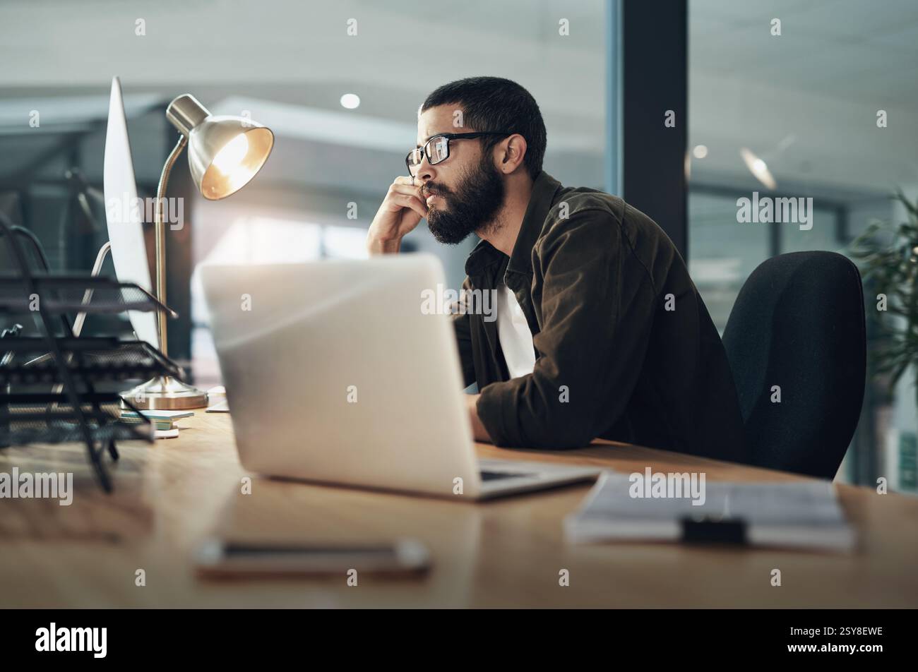 Computer, lettura e occhiali con un uomo d'affari in ufficio per web designer, strumenti ux o pianificazione. Homepage di codifica, serata e sviluppatore con la persona in Foto Stock