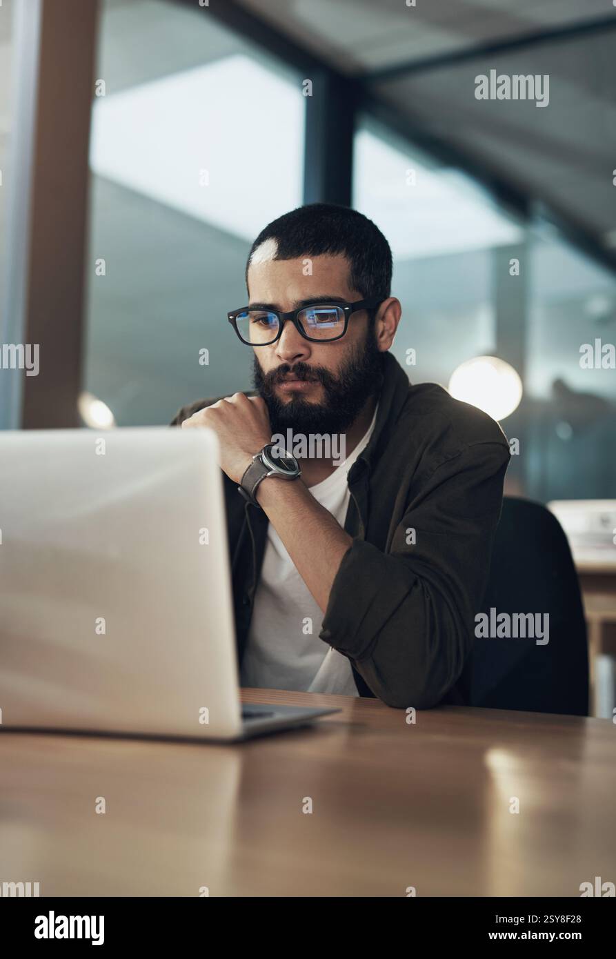 Laptop, pensiero e ricerca con un uomo d'affari in ufficio per Web designer, strumenti ux o pianificazione. Homepage di codifica, serata e sviluppatore con la persona in Foto Stock