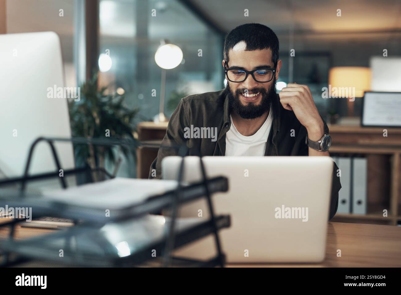 Laptop, sorriso e ricerca con un uomo d'affari in ufficio per Web designer, strumenti ux o pianificazione. Homepage di codifica, serata e sviluppatore con la persona in Foto Stock