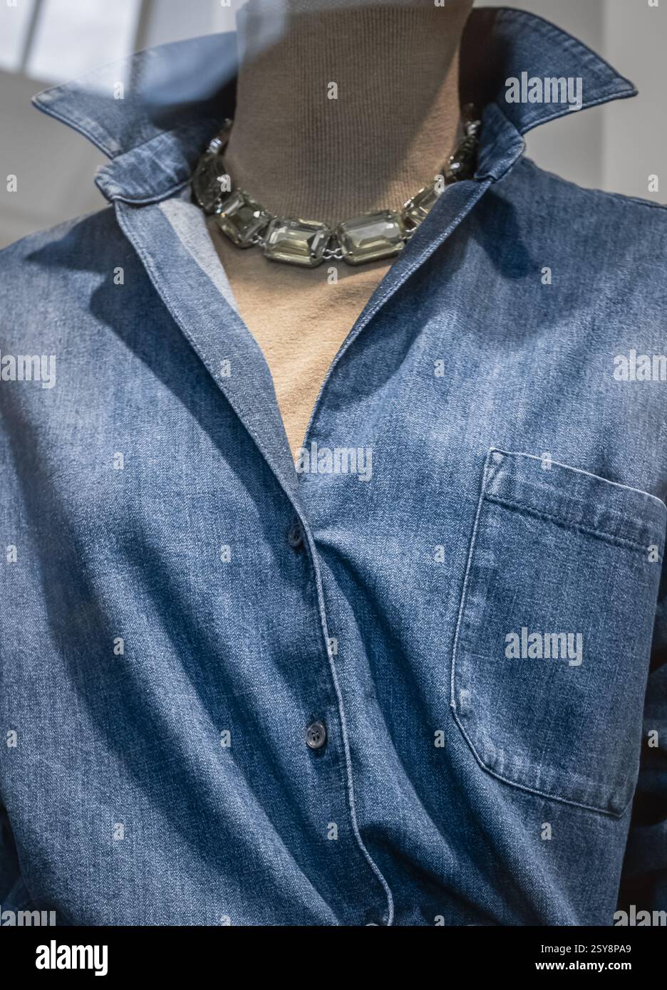 Abbigliamento estivo casual per la stagione della moda su manichini femminili. Camicia da donna in denim blu su un manichino in un negozio di abbigliamento. Luce per la visione anteriore Foto Stock