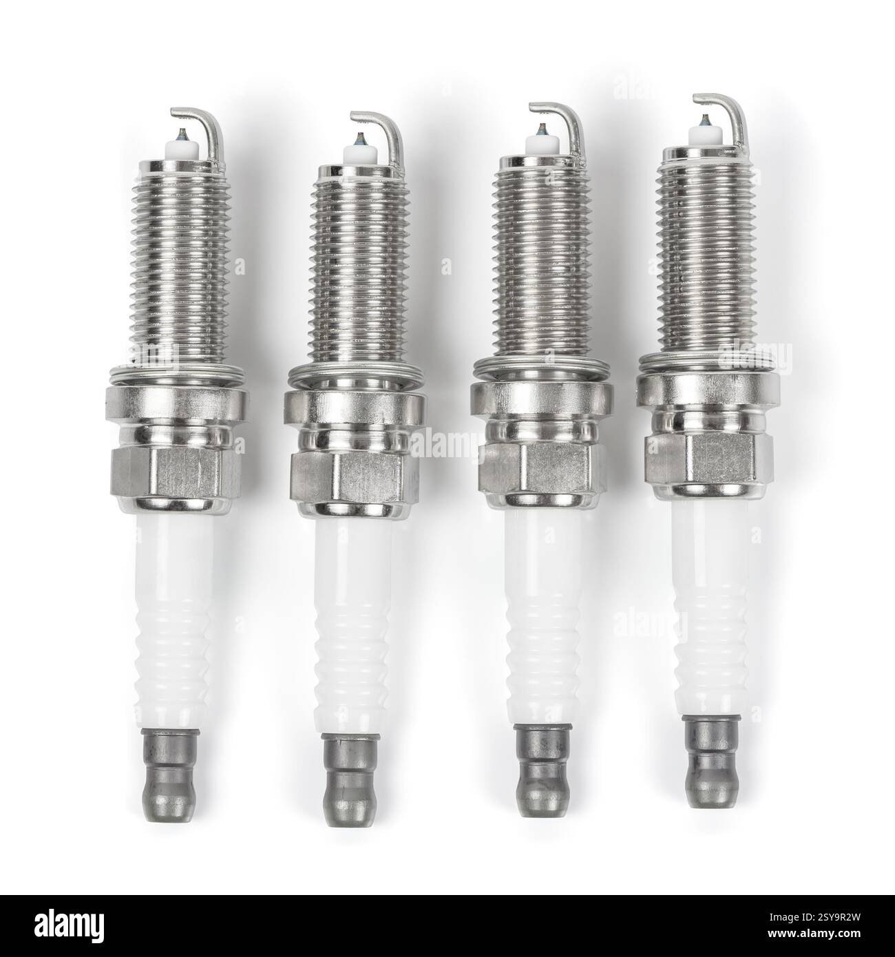 Quattro candele di iridio in fila isolate su sfondo bianco con percorso di taglio Foto Stock
