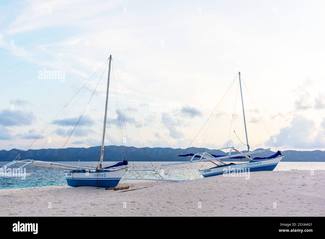 Due bancas sulla spiaggia di sabbia bianca dell'isola Dimakya a Palawan, Filippine nel tardo pomeriggio Foto Stock