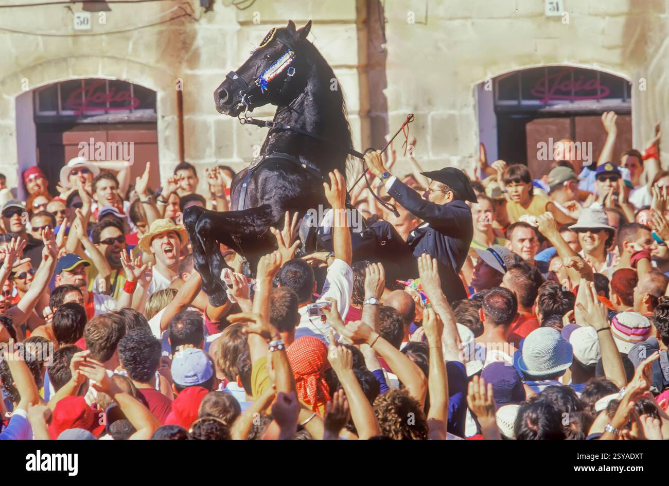 Cavalca su un cavallo che salta tra la folla, St. John Festival, Ciutadella, Minorca, Isole Baleari, Spagna Foto Stock