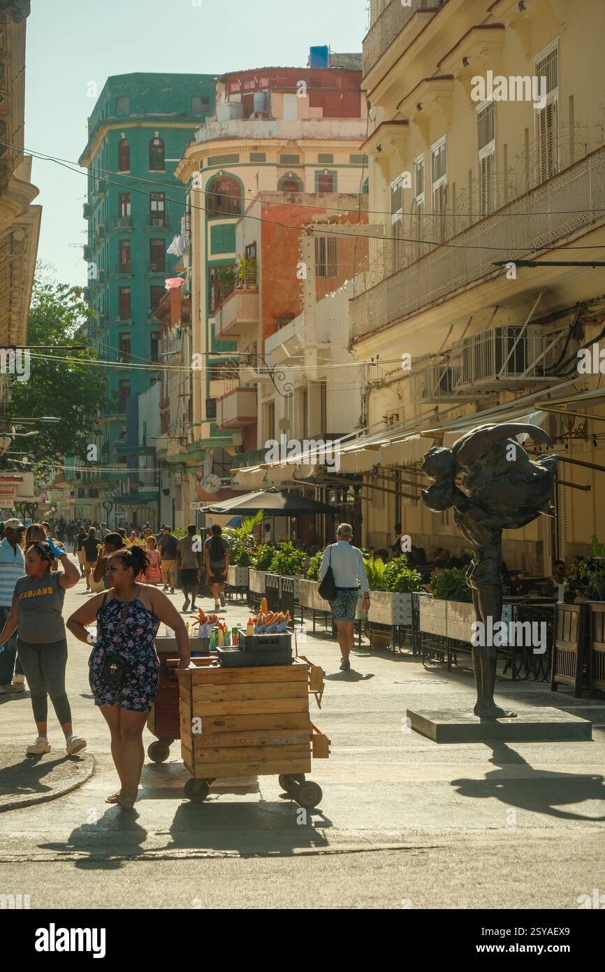 L'Avana, Cuba 2024 aprile. Venditrice di cibo di strada che vende churros lungo la vivace via San Rafael, di fronte all'Hotel Inglaterra nella Vecchia Avana nelle giornate di sole. Foto Stock