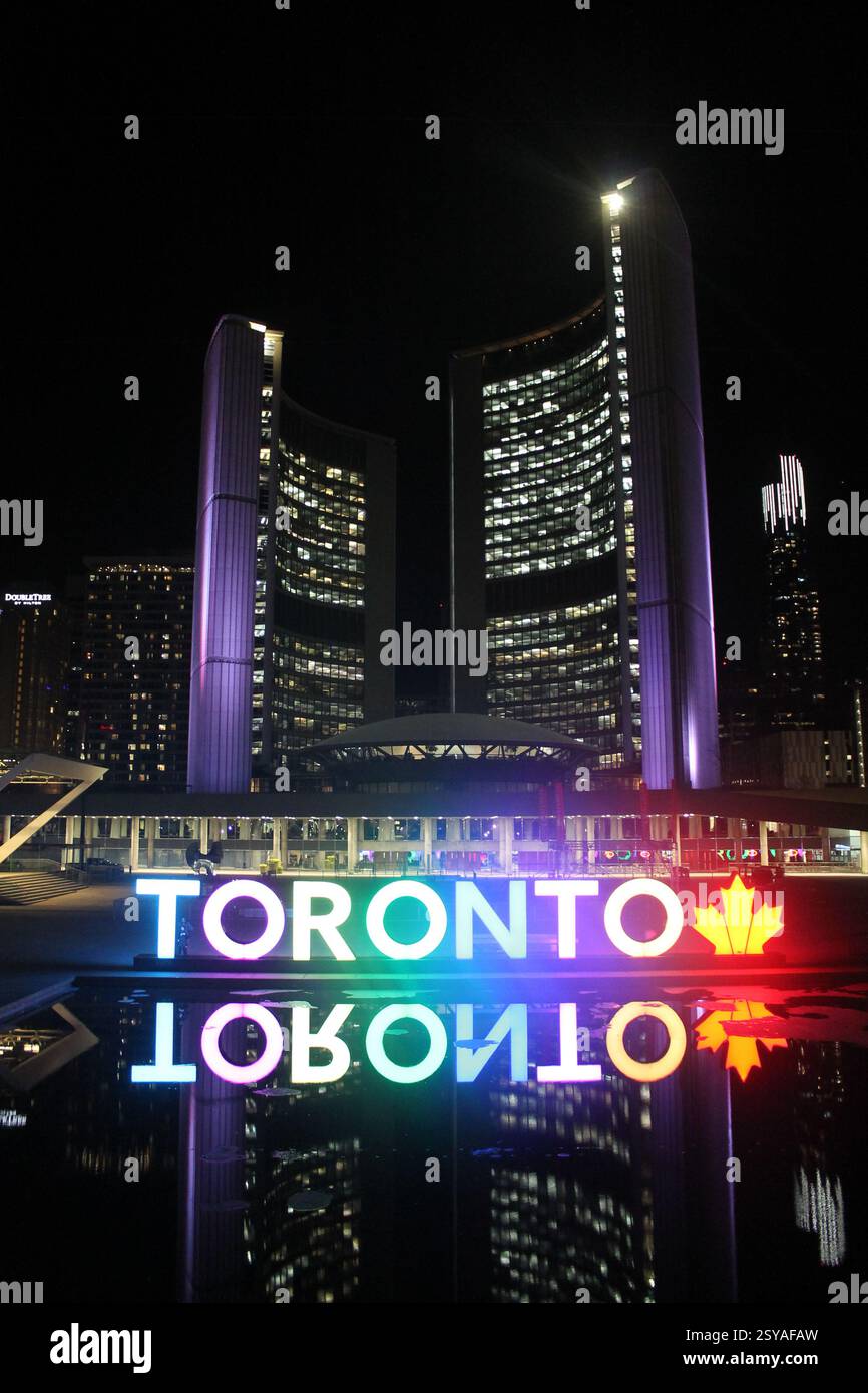 Toronto, Canada - 27 aprile 2017: Cartellone colorato illuminato di Toronto in Nathan Phillips Square di notte con illuminazione arcobaleno, icona a foglia d'acero e refl Foto Stock