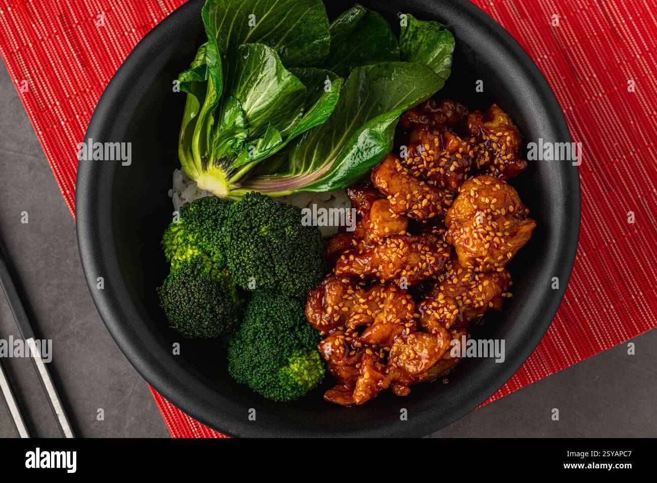 Ciotola di pollo Teriyaki con broccoli e bok choy su un tavolo in pietra grigia Foto Stock