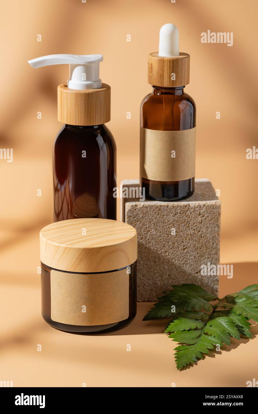 Un'elegante disposizione di bottiglie cosmetiche su sfondo beige, con un elegante packaging con elementi naturali, che trasmette un aspetto minimalista ed eco-ven Foto Stock