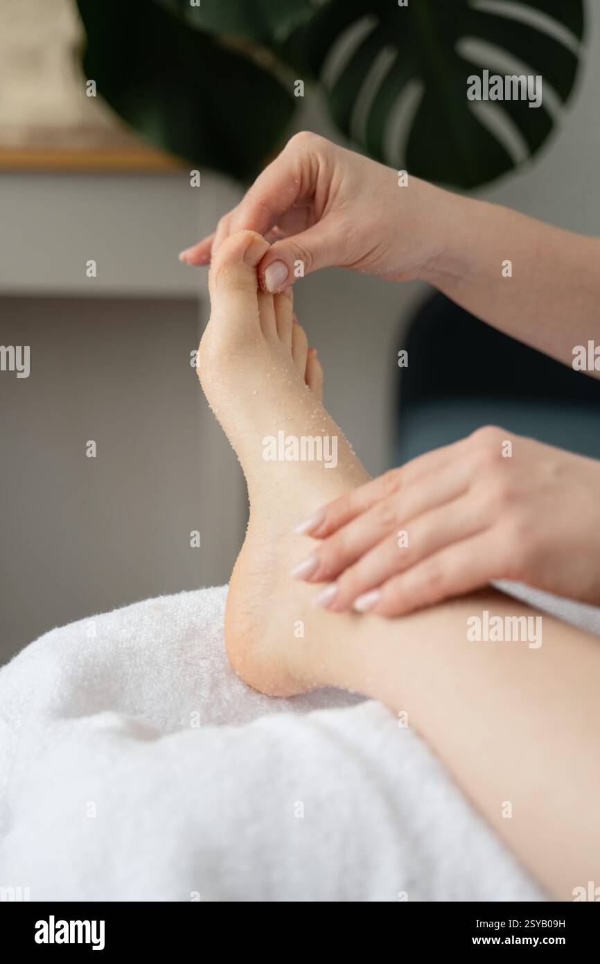 Goditi un momento di tenerezza come un legame tra madre e figlia attraverso una sessione di cura dei piedi a casa. Concentrarsi sul relax, l'autocura e l'amore per la famiglia. Foto Stock
