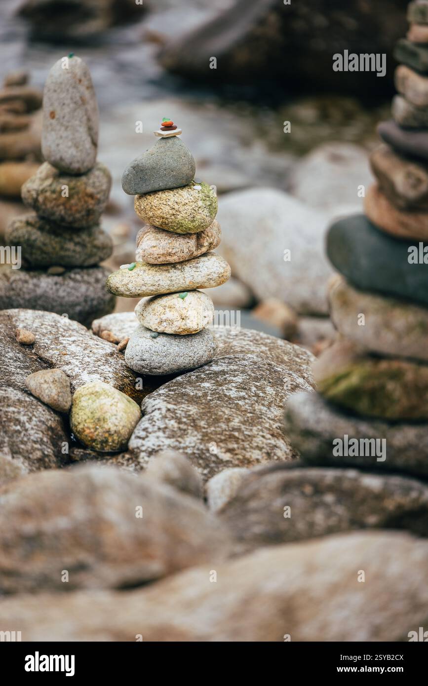 Una pila di pietre bilanciate su una superficie rocciosa in un tranquillo ambiente esterno accanto al mare. Concetto di equilibrio, meditazione e tranquillità per natur Foto Stock