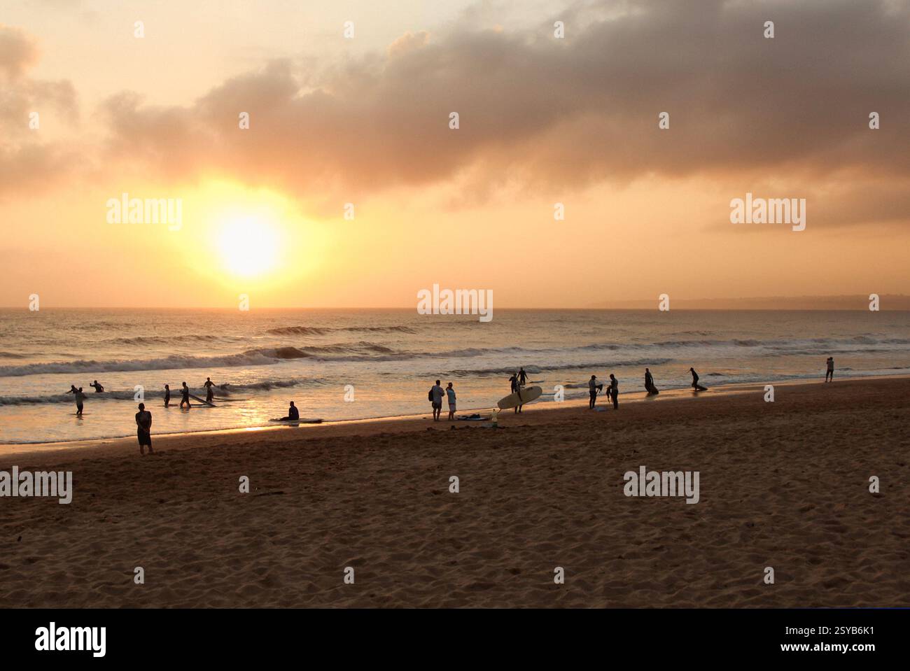 Surfista bei Sonnenuntergang am Strand Foto Stock