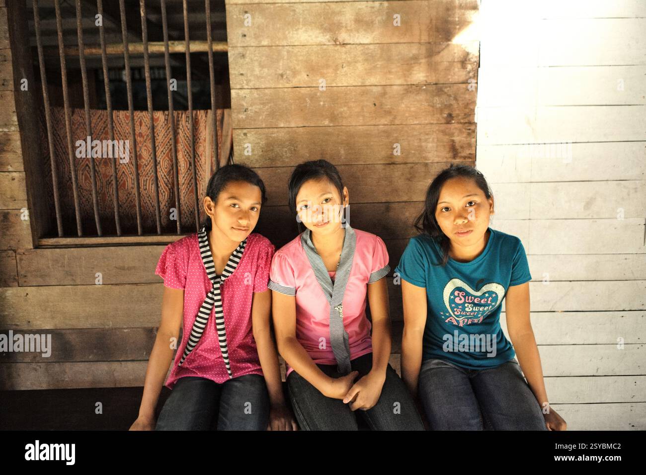 Ritratto di un gruppo di ragazze sedute sul portico della casa di riposo della comunità tradizionale Dayak IBAN a Sungai Utik, Batu Lintang, Embaloh Hulu, Kapuas Hulu, West Kalimantan, Indonesia. Le donne e le ragazze indigene affrontano gravi, sistematici e continui atti di violenza che permeano ogni aspetto della loro vita, mentre gli autori godono di livelli allarmanti di impunità, Reem Alsalem, un esperto delle Nazioni Unite sulla violenza contro le donne, ha spiegato in una relazione al Consiglio per i diritti umani a Ginevra nel giugno 2022. "Questa violenza è radicata in strutture di potere patriarcali storiche e disuguali, razzismo, esclusione, Foto Stock