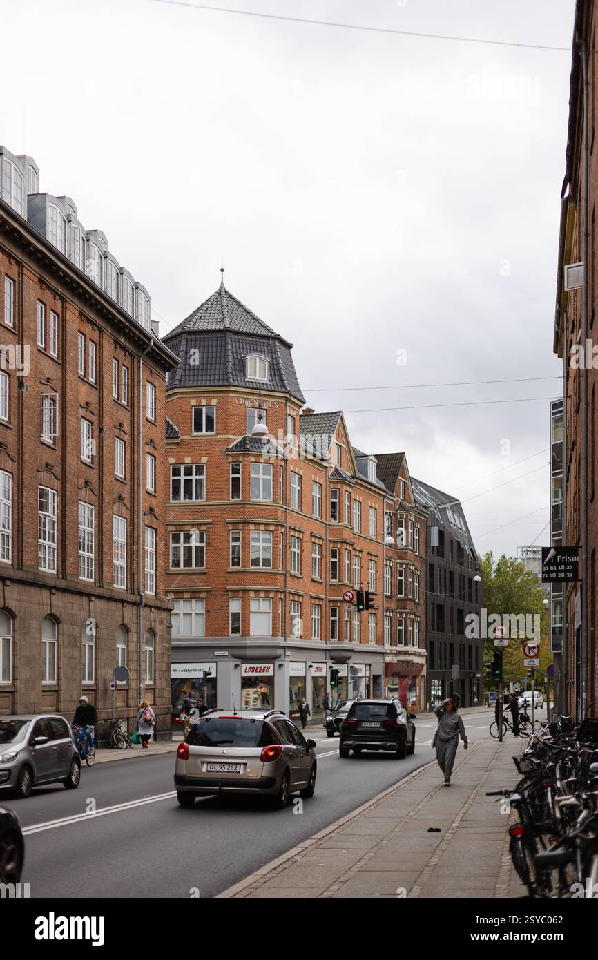 Strada cittadina di Aarhus con traffico auto e edifici danesi in mattoni rossi Foto Stock