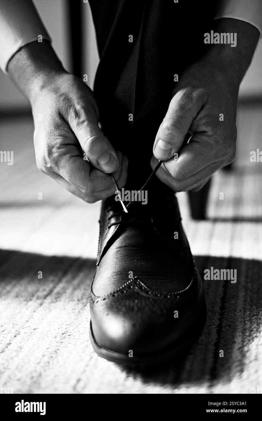 Allacciare lacci di scarpe a scarpe formali in bianco e nero Foto Stock