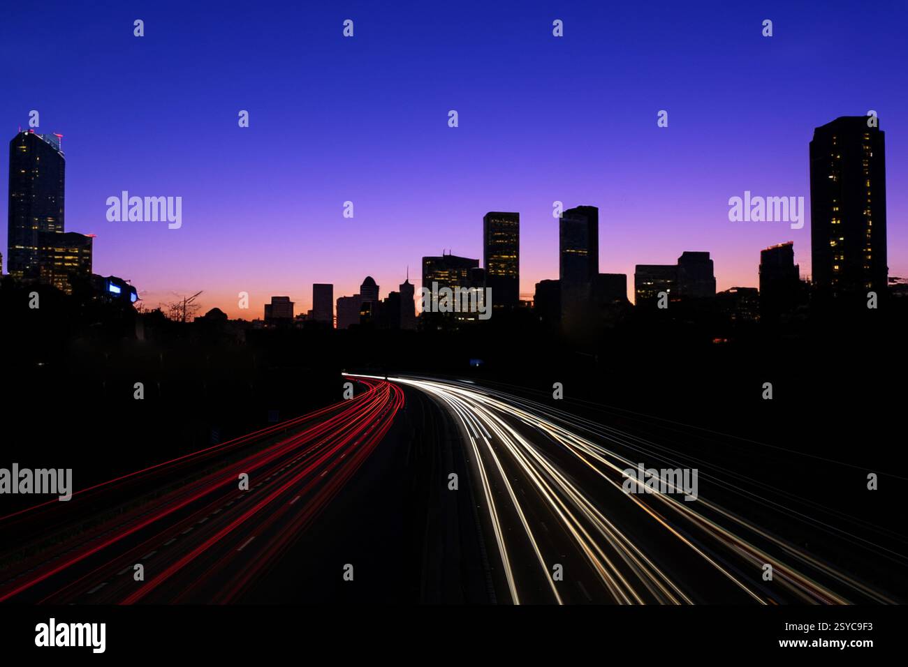 Scena notturna drammatica con skyline della città e Light Trails Foto Stock