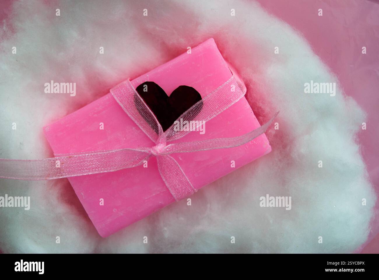 Sapone rosa realizzato a mano su un morbido sfondo bianco. Foto Stock