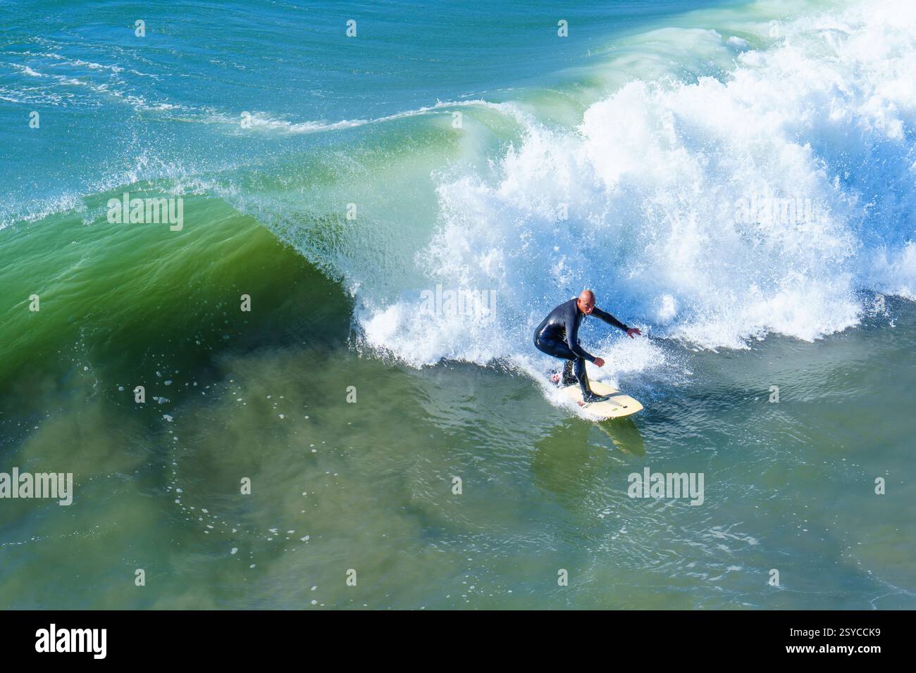 Oceanside, California - 26 dicembre 2024: Surfista sapientemente cavalcando una grande onda nell'Oceanside sotto il cielo azzurro. Foto Stock