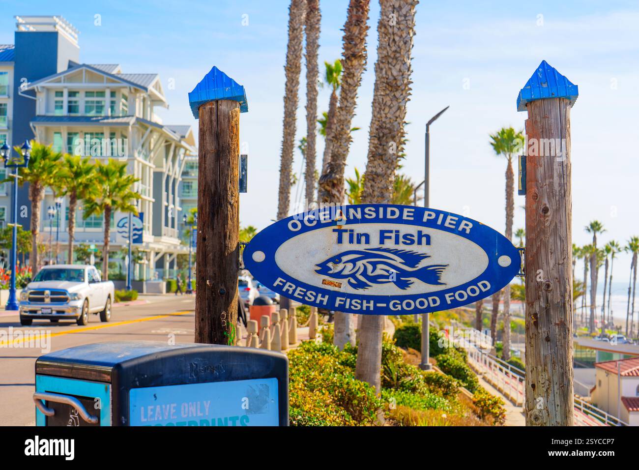 Oceanside, California - 27 dicembre 2024: Cartello del ristorante Tin Fish presso il molo Oceanside con auto che passano e palme in vista. Foto Stock