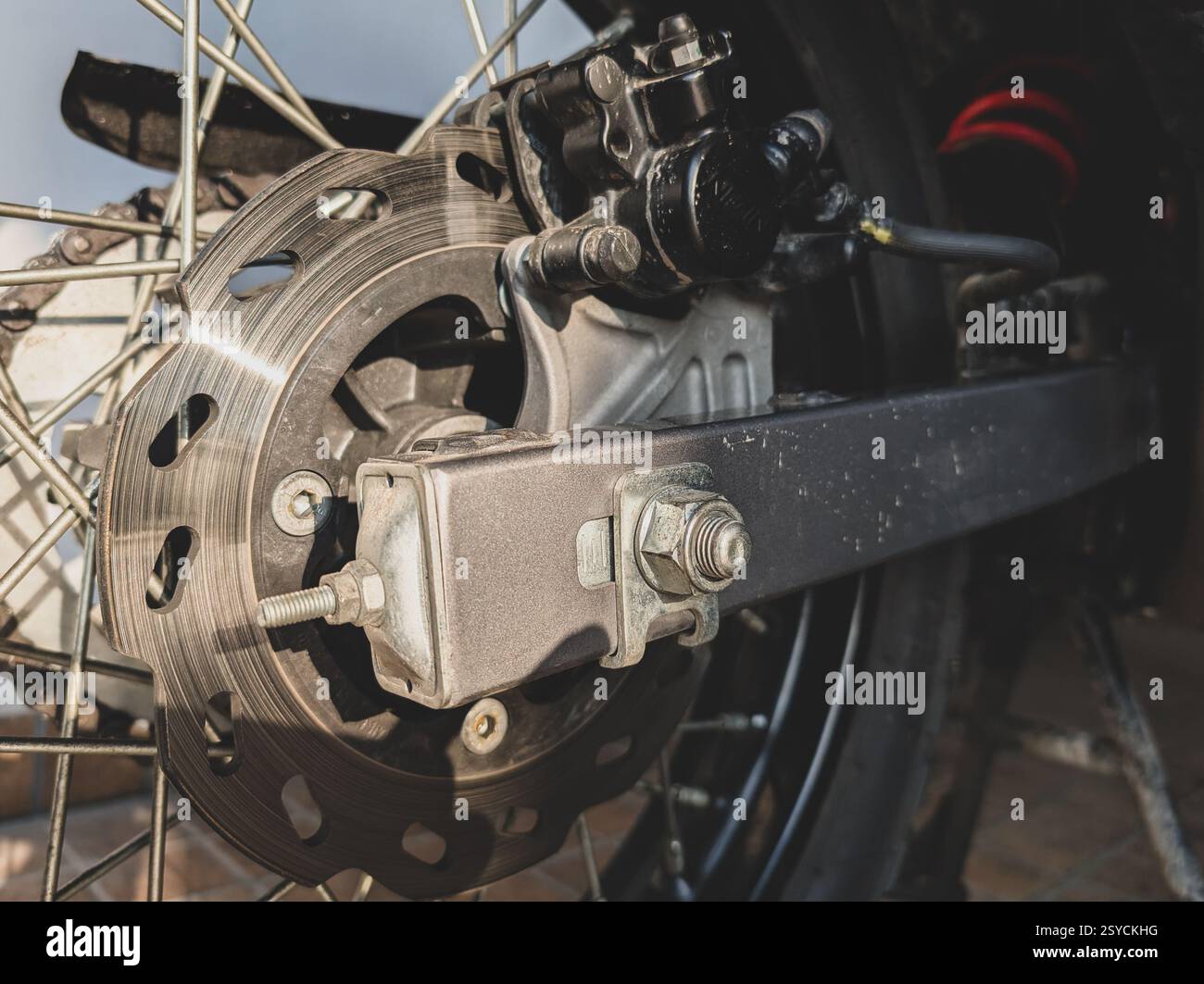 15-2025 Dehradun Uttarakhand India. Meccanismo del freno a disco e forcellone su una motocicletta moderna per l'avventura, India. Foto Stock