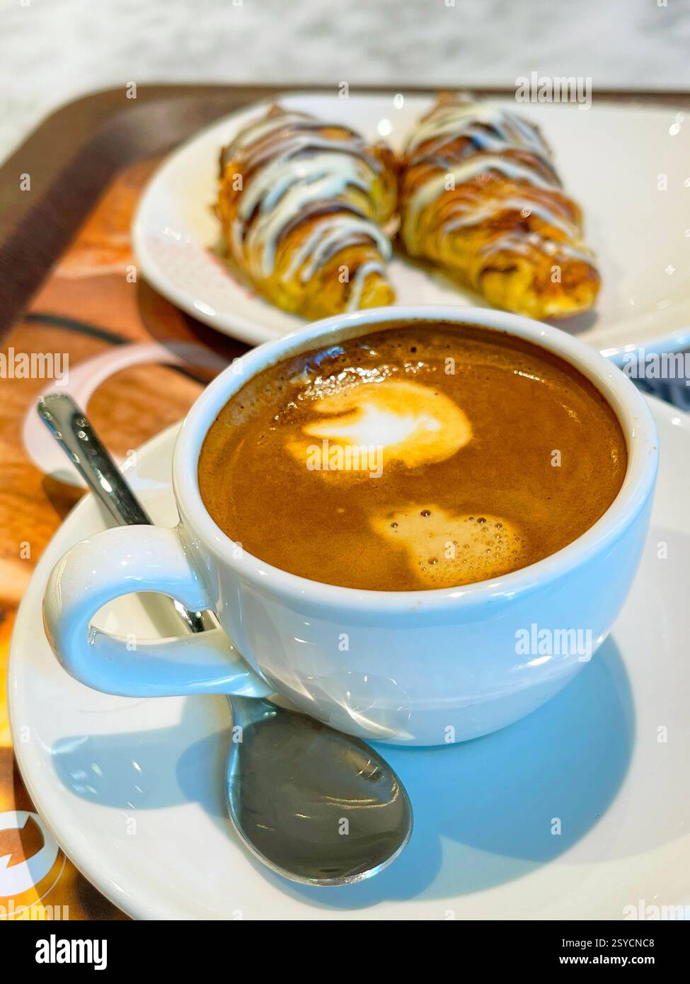 Tazza di caffè con due torte di pasta sfoglia. - Immagine stock catturata con smartphone