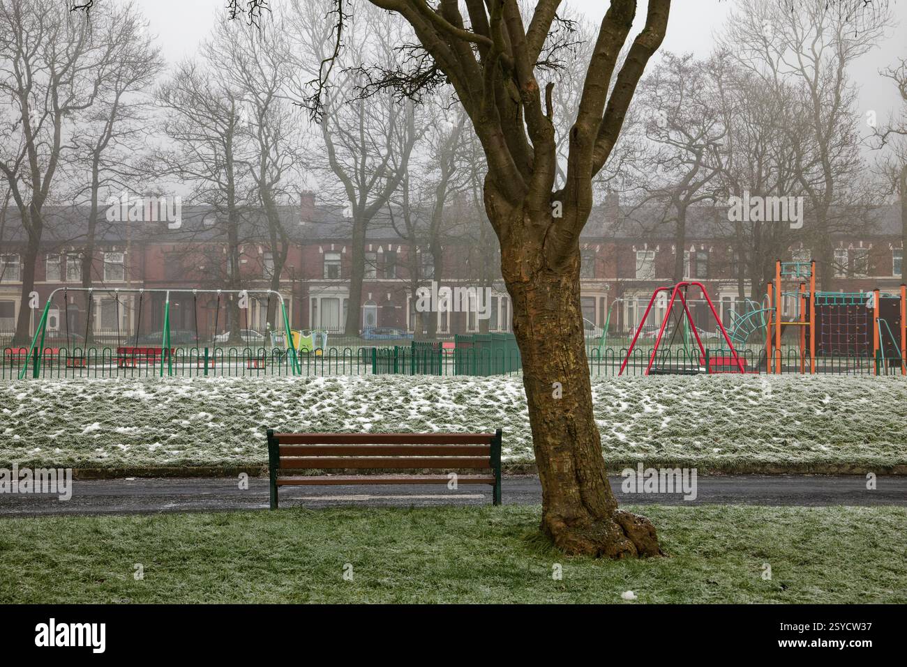 Area giochi deserta con freddo nebbioso inverno a Clarence Park, Bury, Greater Manchester. Foto Stock