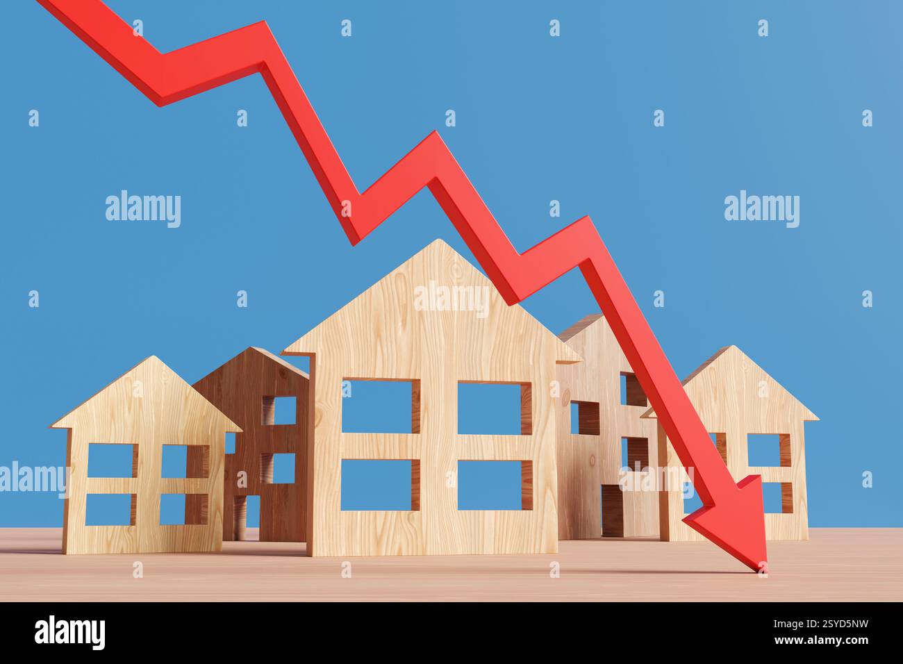 Freccia rossa verso il basso davanti ai modelli di case in legno su un tavolo di legno su sfondo blu. Concetto di riduzione dei prezzi delle proprietà immobiliari Foto Stock