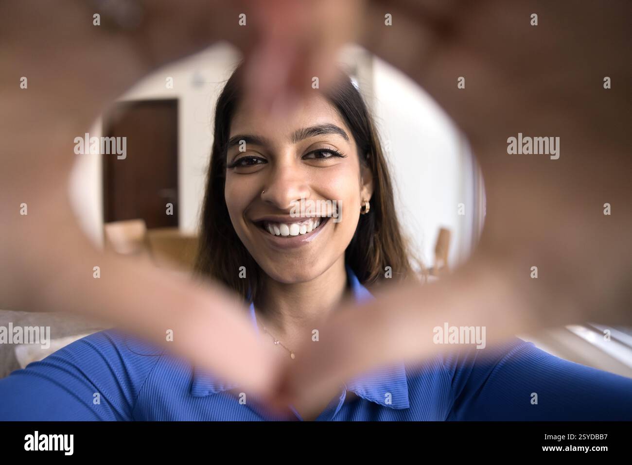 Donna indiana che mostra il simbolo del cuore con le mani Foto Stock