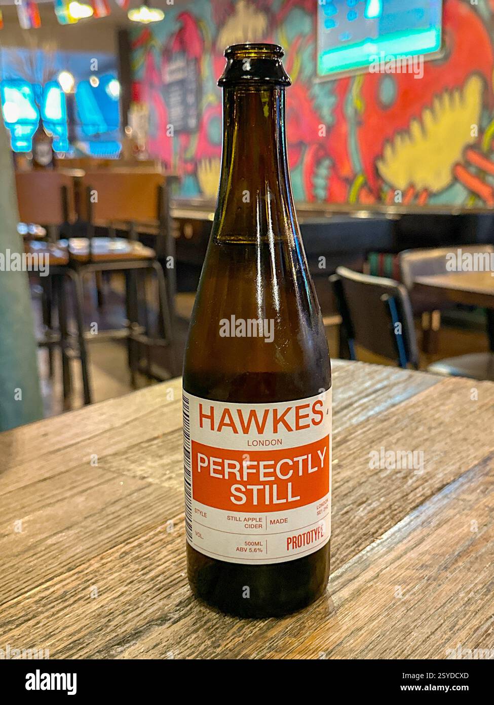 Londra, Inghilterra, Regno Unito - 3 luglio 2024: Bottiglia di sidro naturale prodotta da Hawkes di Londra su un tavolo in un bar - Immagine stock catturata con smartphone