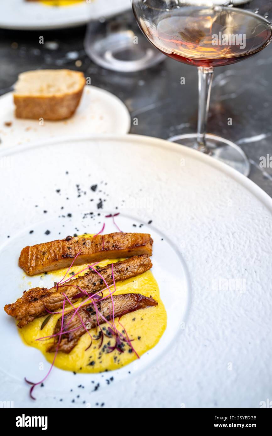 Un menu gourmet di degustazione mette in mostra tenero maiale iberico abbinato a squisiti vini sherry in un raffinato ristorante di Siviglia. Foto Stock