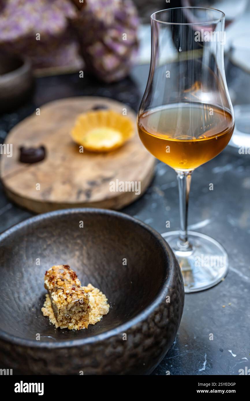 Un dessert decadente abbinato a un bicchiere di vino Sherry mette in evidenza un menu degustazione gourmet in un ristorante alla moda di Siviglia, Spagna. Foto Stock