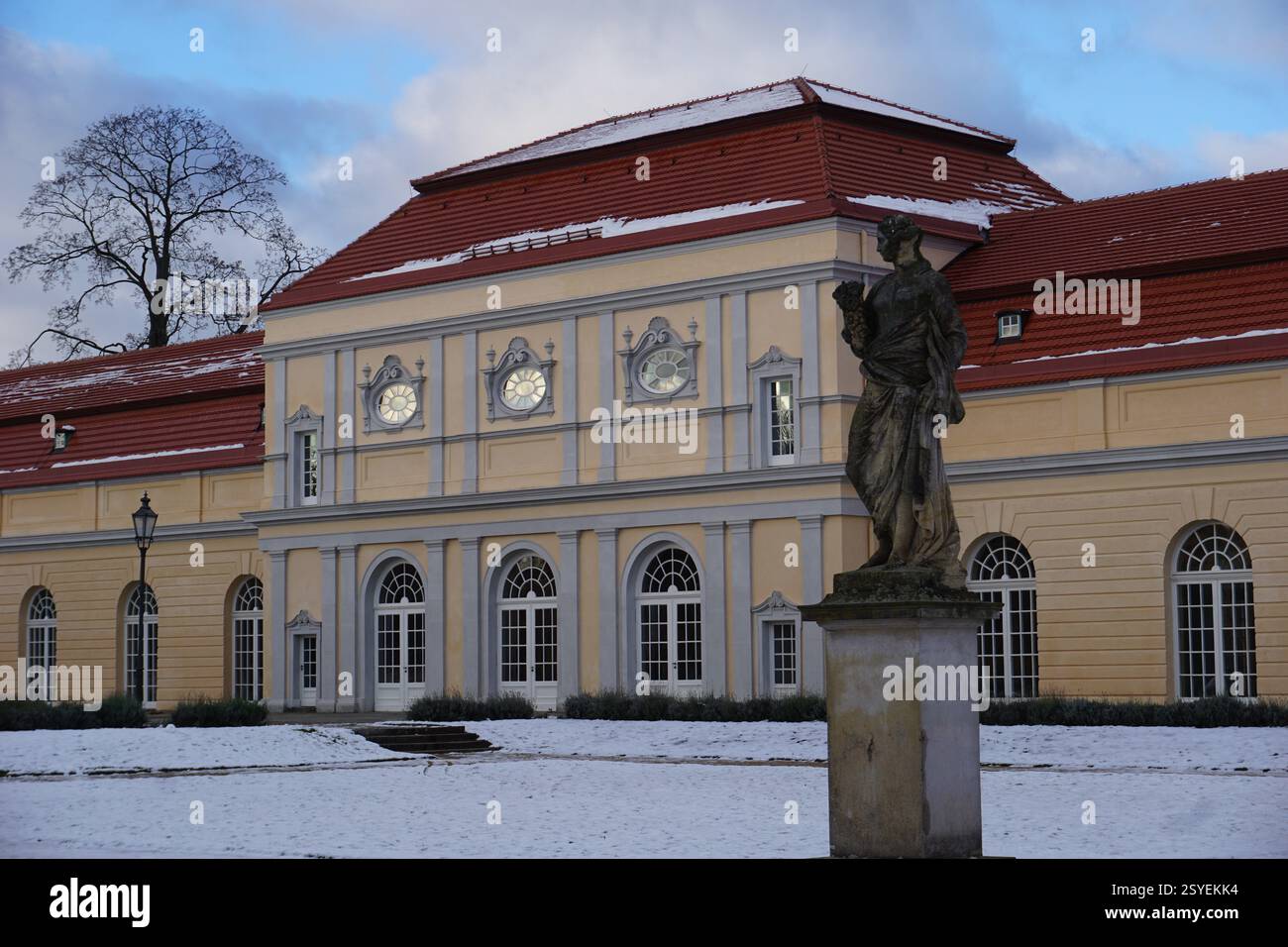 La neve copre il giardino e una statua storica prima della nuova ala del castello di Charlottenburg, Berlino, Germania, in un giorno d'inverno Foto Stock