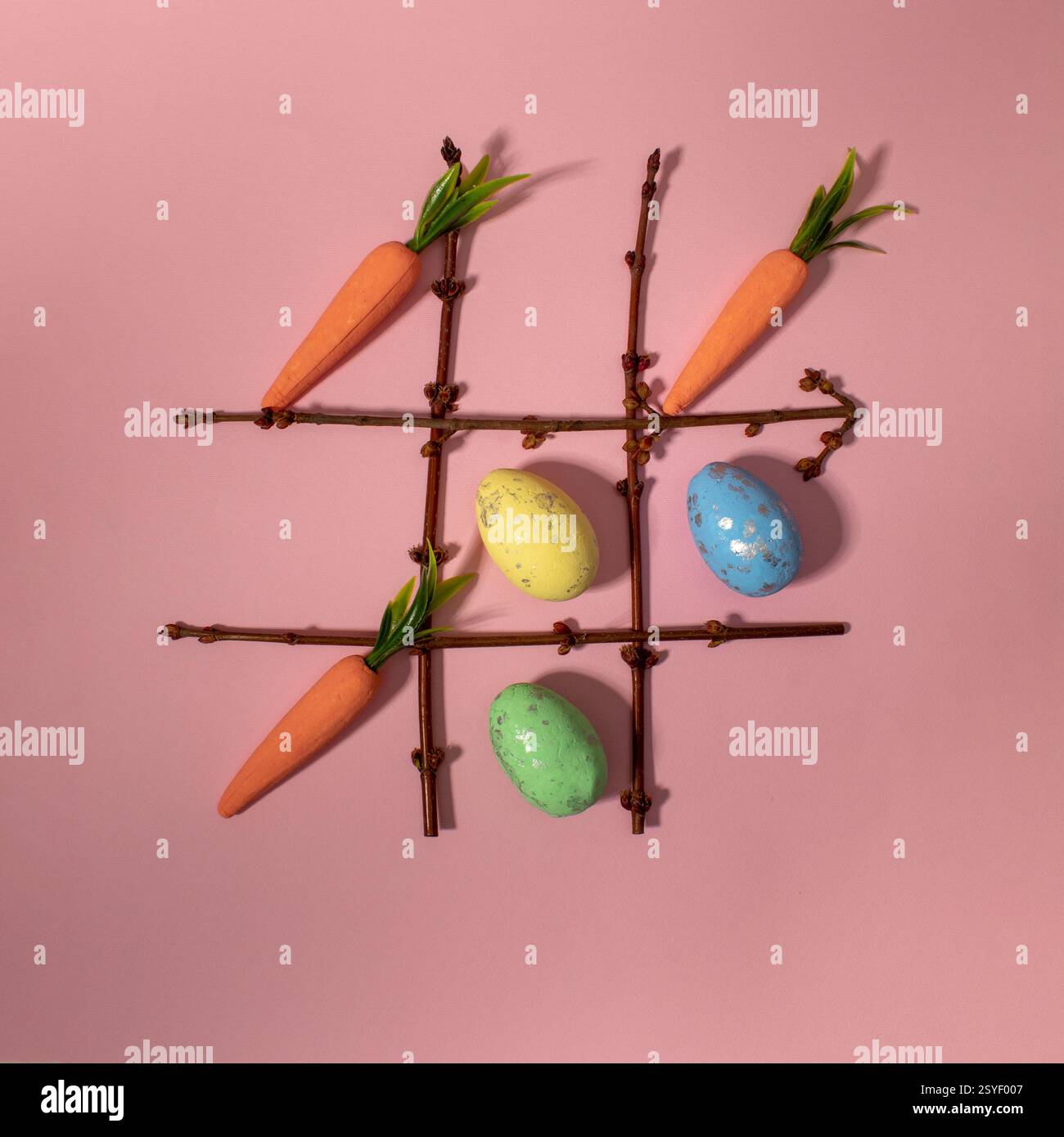 TIC tac con elementi pasquali carote e uova. Posizione piatta. Foto Stock