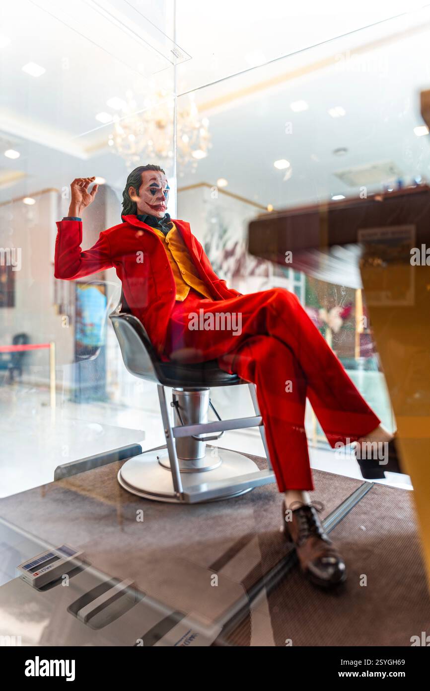 Bangkok Tailandia - 20 febbraio 2025: Figura modello Joker personaggio di Batman, il cavaliere oscuro dei film DC, seduta sulla sedia da barbiere di fronte Foto Stock