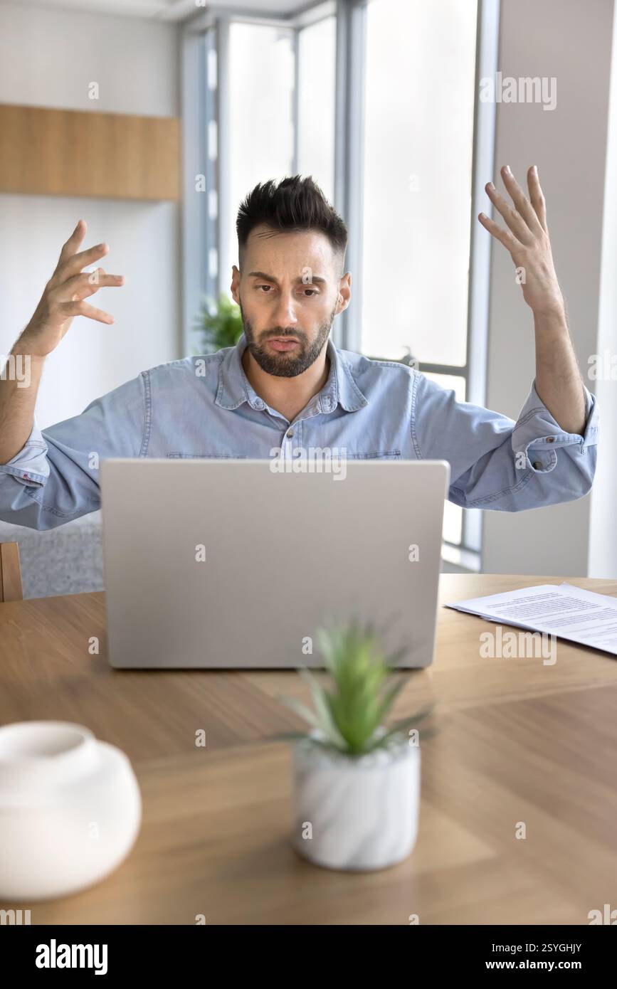 L'uomo infastidito che utilizza un notebook ha problemi con il dispositivo Foto Stock