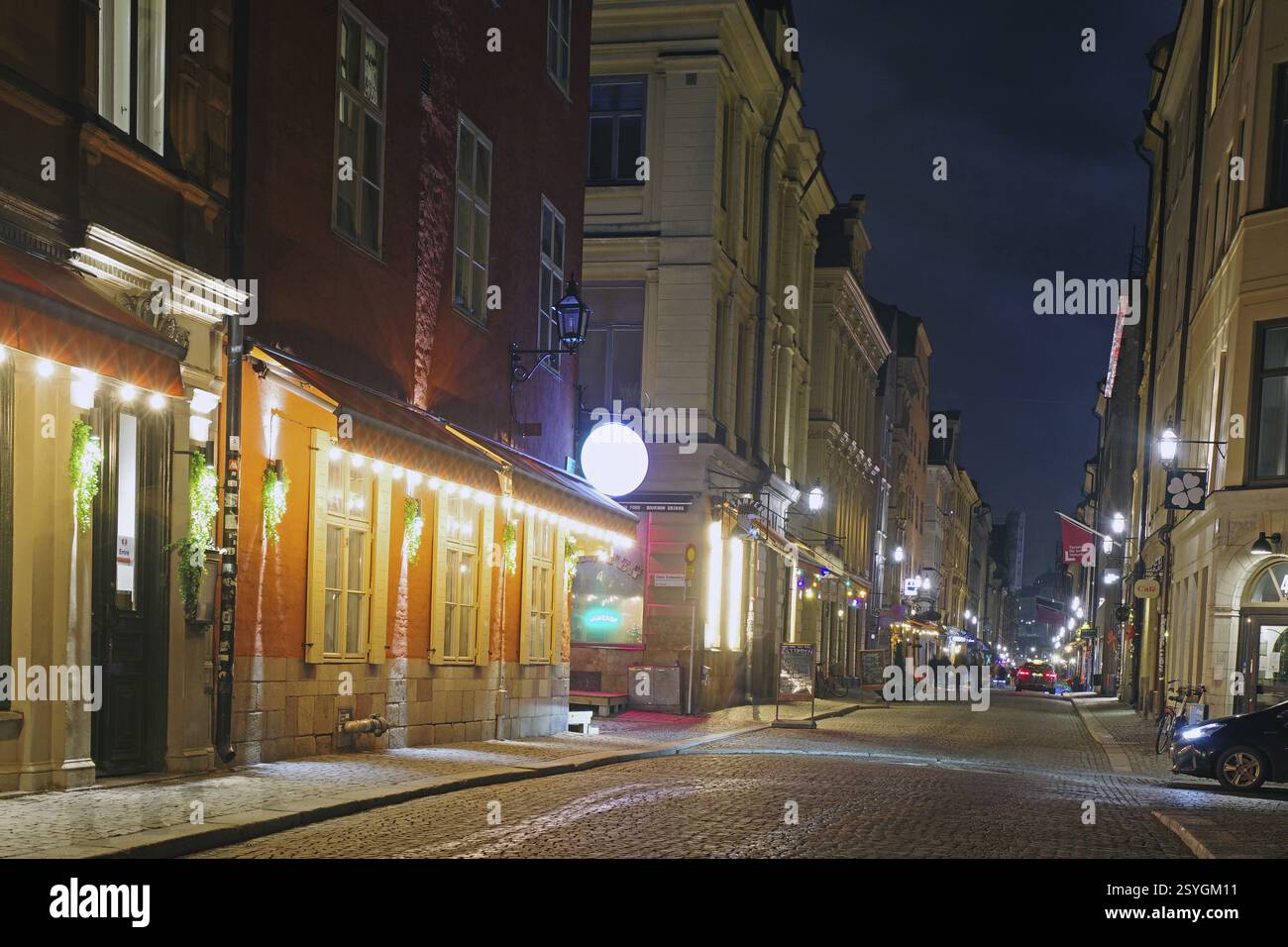 Foto notturna di una strada accogliente con vecchi edifici e una calda luce lanterna in una città, in inverno, Gamla Stan, la città vecchia, Stoccolma Svezia Foto Stock Foto notturna di una strada accogliente con vecchi edifici e una calda luce lanterna in una città, in inverno, Gamla Stan, la città vecchia, Stoccolma Svezia Foto Stock
