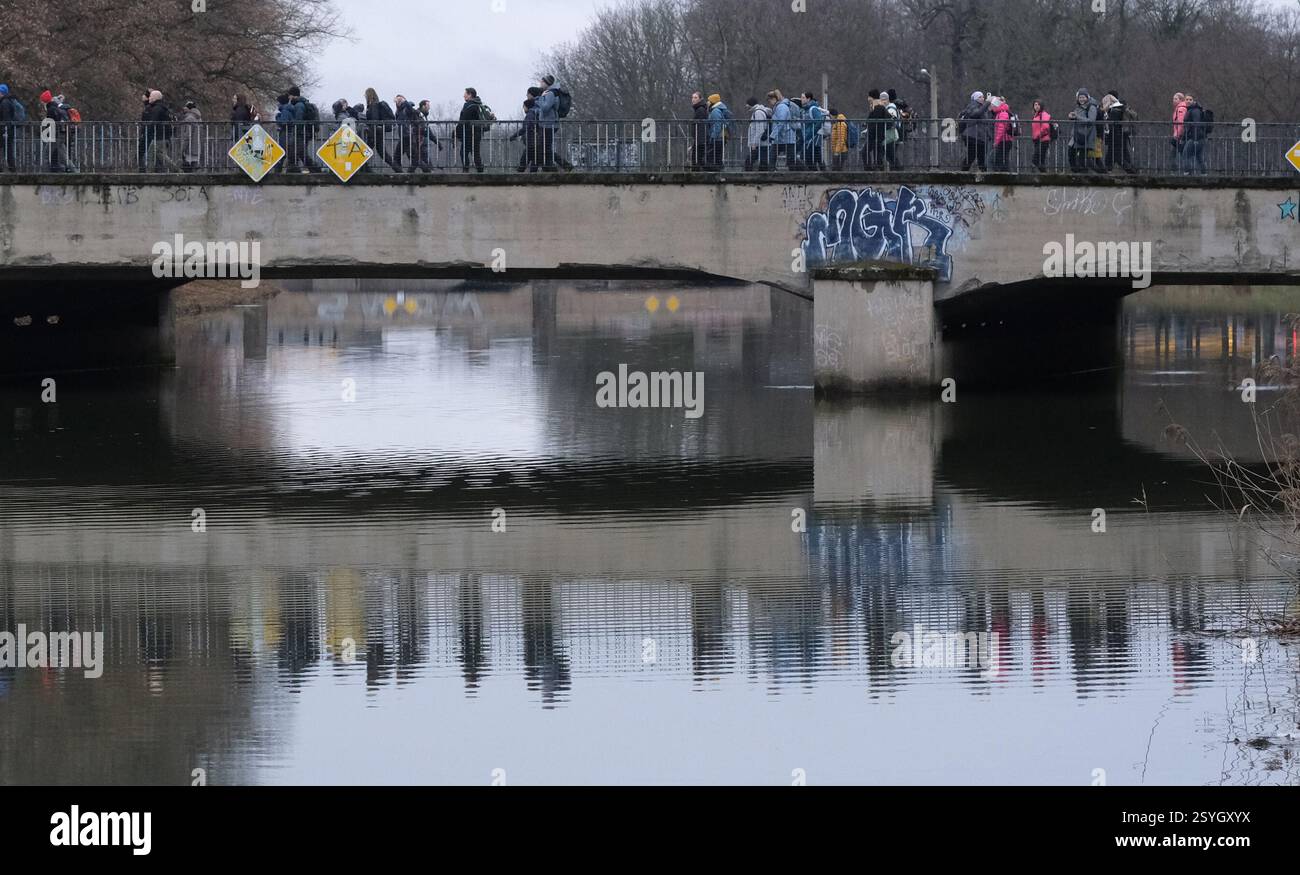 Lipsia, Germania. 1 marzo 2025. I partecipanti all'evento escursionistico "Mammutmarsch" attraversano un ponte. L'inizio meteorologico della primavera è fresco e umido nella Germania centrale. Crediti: Sebastian Willnow/dpa/Alamy Live News Foto Stock