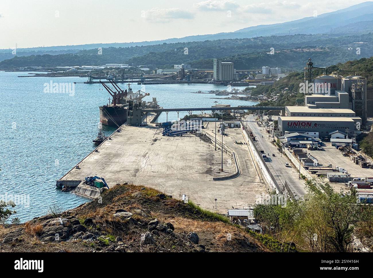 Penisola di Bataan, Filippine. 28 febbraio 2025. Il Mariveles Multi Purpose Terminal (MMT), l'infrastruttura del porto per la rinfusa di Mariveles Harbor Corporation, posseduta al 88% dalla società mineraria quotata Global Ferronickel Holdings Inc (FNI), situata nell'area del Freeport di Bataan, una zona economica speciale con incentivi fiscali e duty free. Il porto, all'estremità settentrionale della baia di Manila, consente alle navi Supramax di scaricare carbone, fertilizzanti, acciaio, clinker, sabbia di silice, gesso e altre materie prime di cemento (il complesso industriale ospita Union Cement by Philcement Processing Plant). Crediti: Kevin Izorce/Alamy Live News Foto Stock