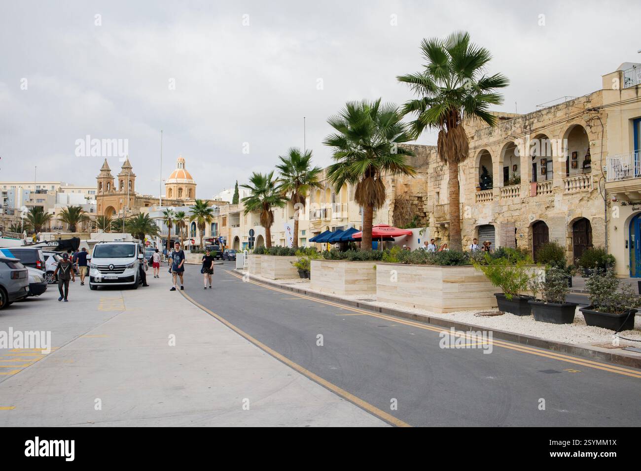 Marsaxlokk, il centro di Malta e i turisti che camminano intorno Foto Stock