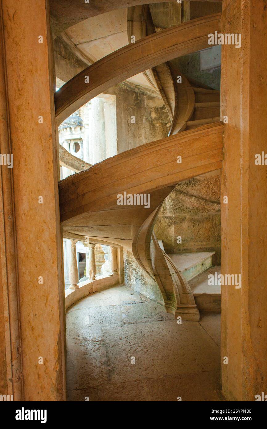 una tortuosa scalinata in pietra con intricati dettagli architettonici che creano un senso di mistero e intrigo all'interno dell'edificio storico. Foto Stock