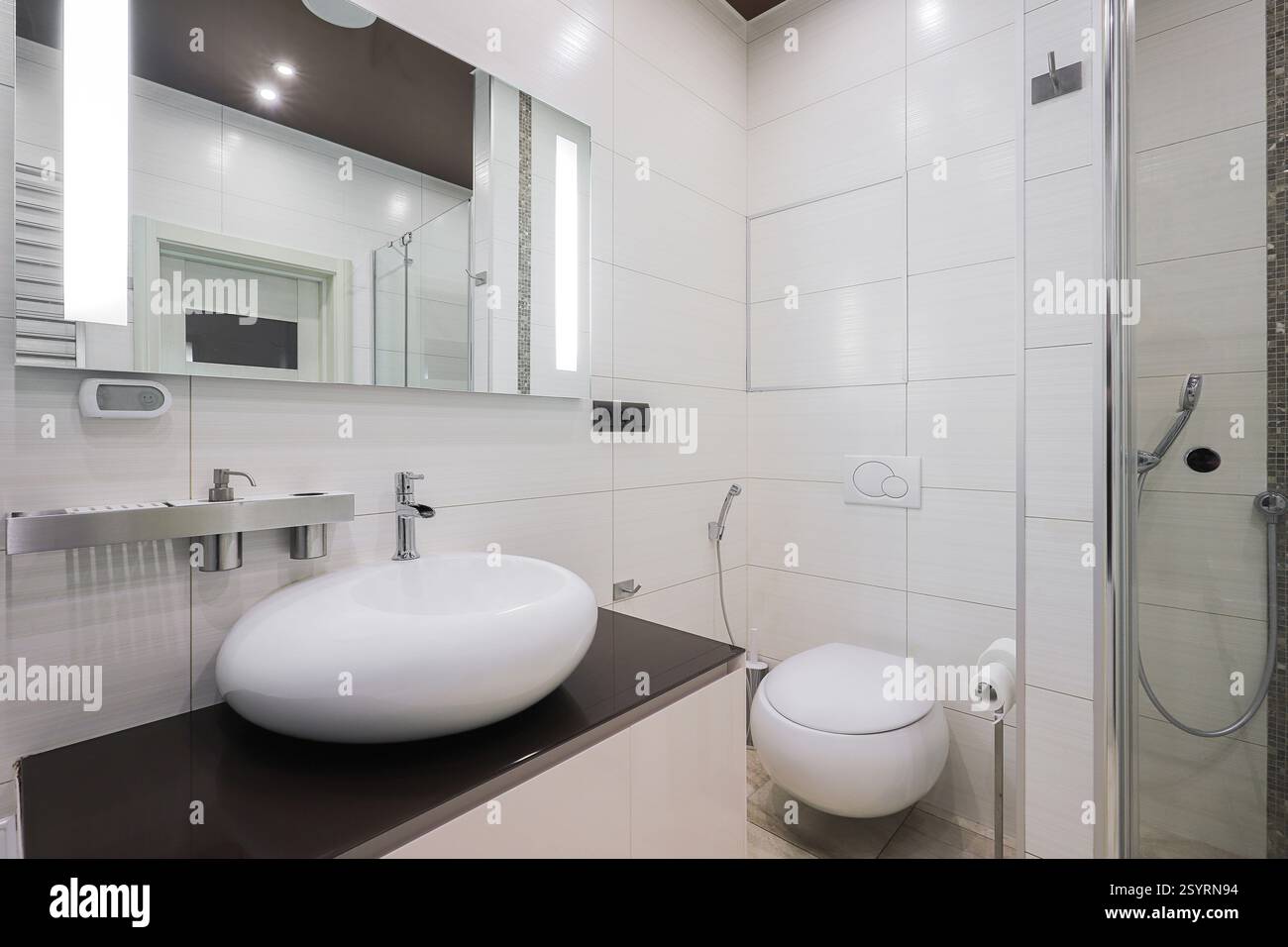 Rubinetto con lavabo in ceramica e specchio all'interno del bagno Foto Stock Rubinetto con lavabo in ceramica e specchio all'interno del bagno Foto Stock