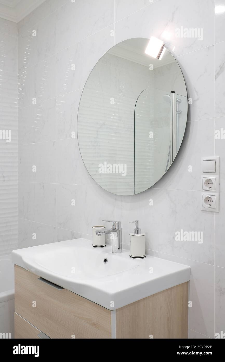 Rubinetto con lavabo in ceramica e specchio all'interno del bagno Foto Stock Rubinetto con lavabo in ceramica e specchio all'interno del bagno Foto Stock