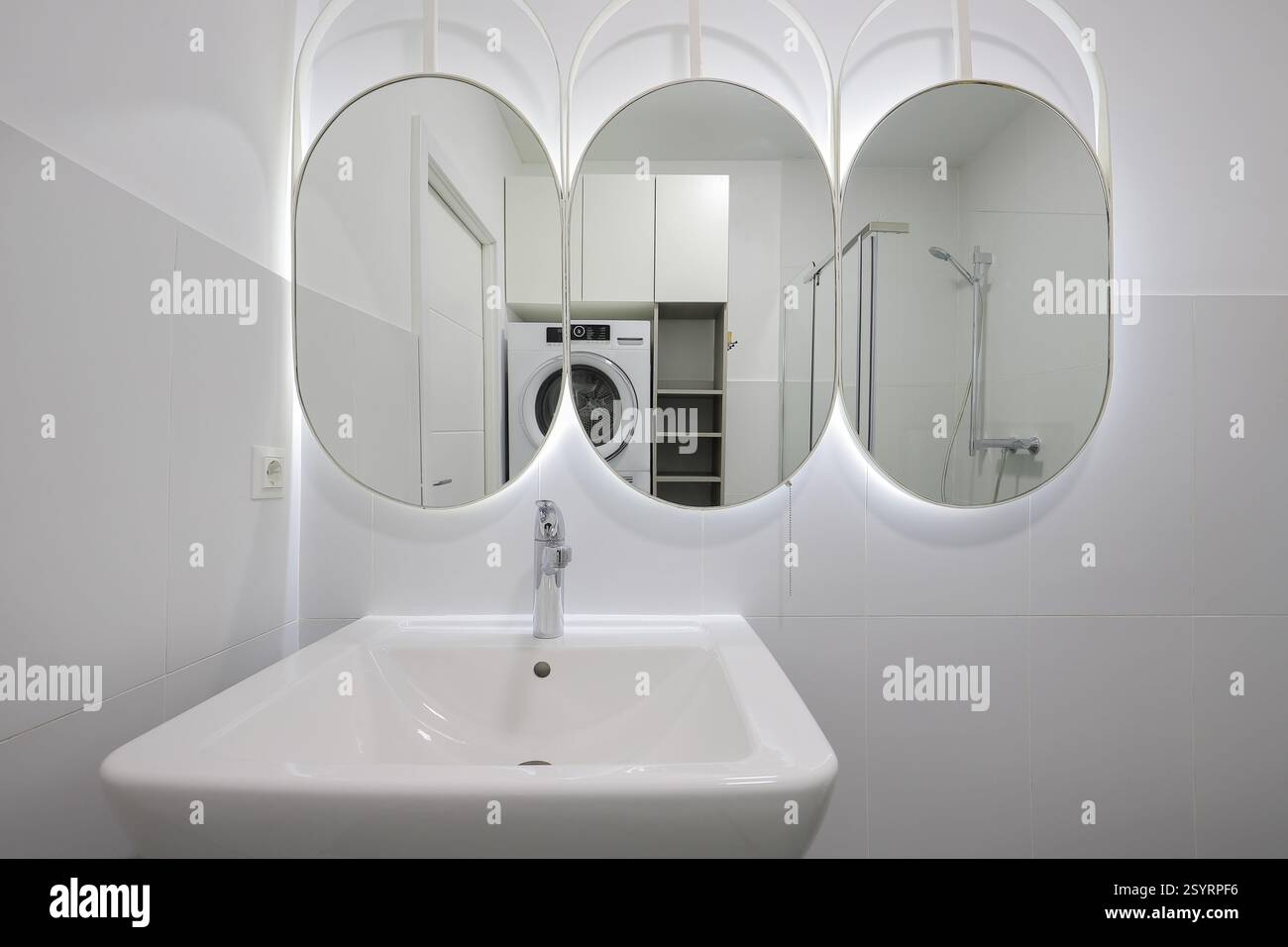Rubinetto con lavabo in ceramica e specchio all'interno del bagno Foto Stock Rubinetto con lavabo in ceramica e specchio all'interno del bagno Foto Stock