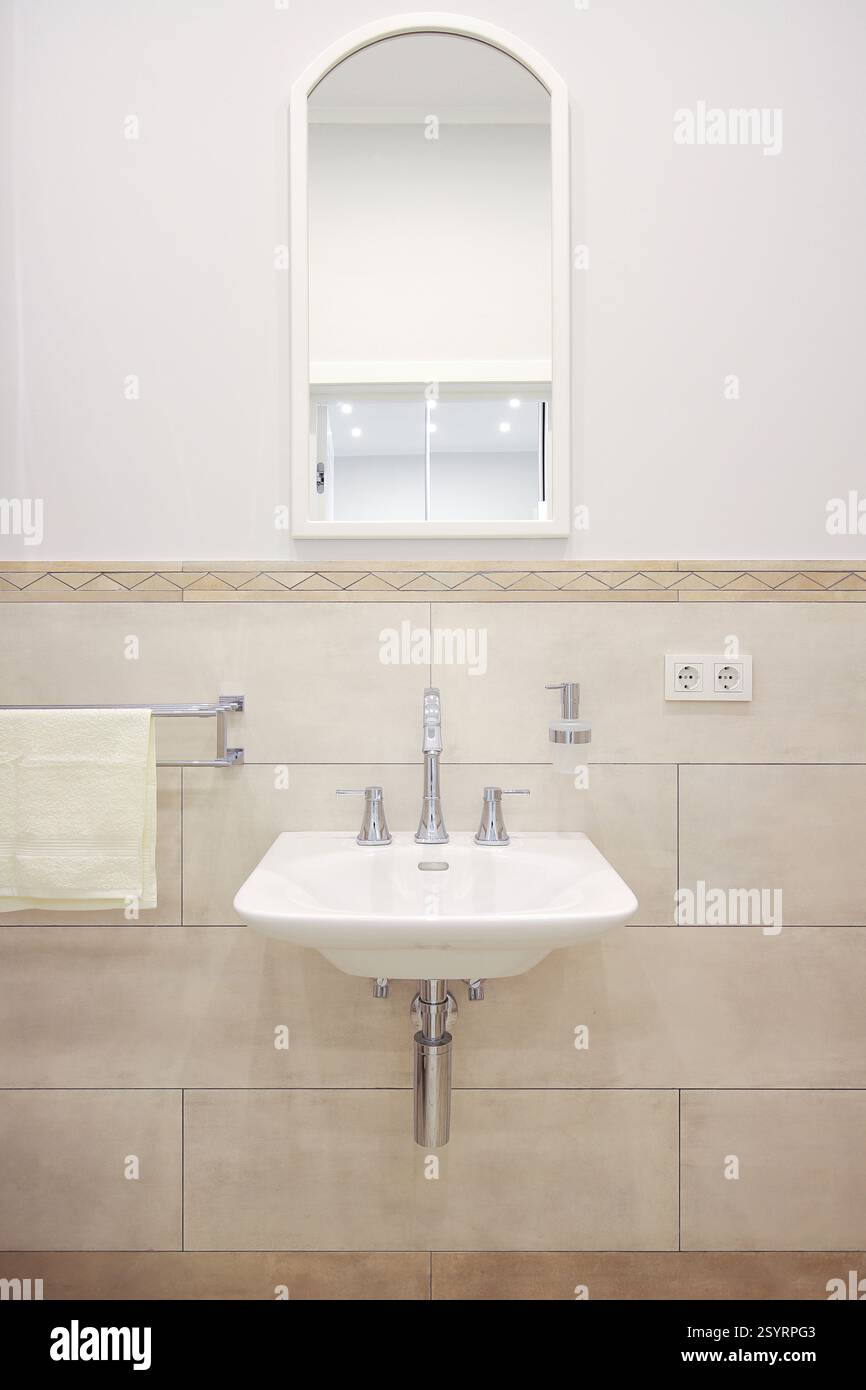 Rubinetto con lavabo in ceramica e specchio all'interno del bagno Foto Stock Rubinetto con lavabo in ceramica e specchio all'interno del bagno Foto Stock