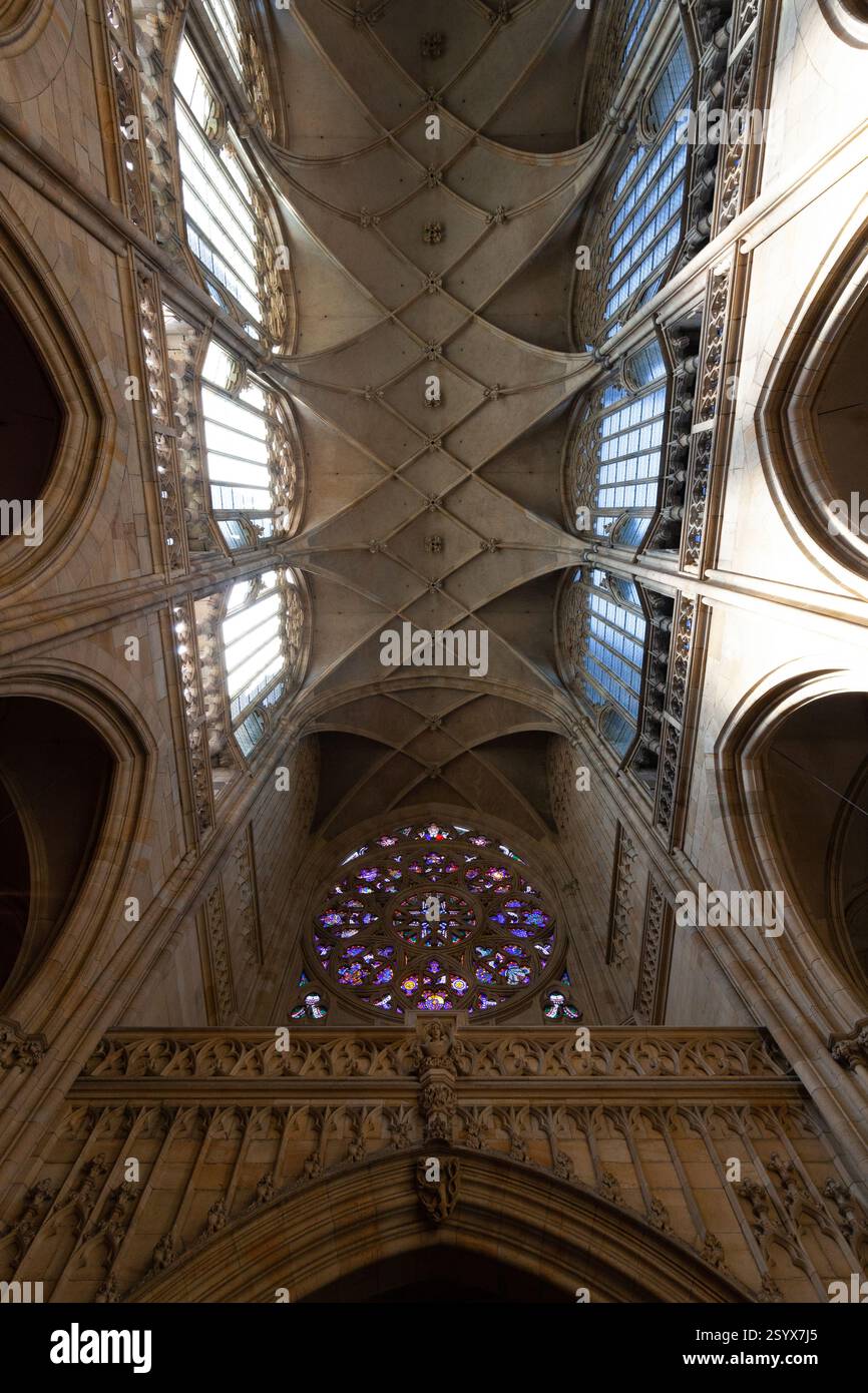 Un'affascinante rosetta con vetrate colorate domina la facciata di una cattedrale gotica, adagiata su uno sfondo di intricati lavori in pietra e così via Foto Stock