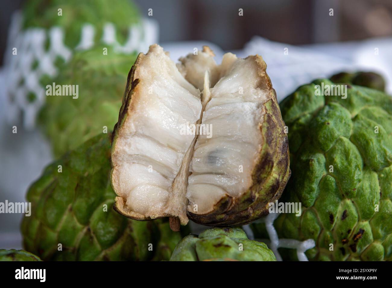 Mela da zucchero aperta o Fruta de Conde (frutto del conte) come è noto in Brasile sul mercato di strada mostrando all'interno con denti carnosi e forma di scala esterna Foto Stock