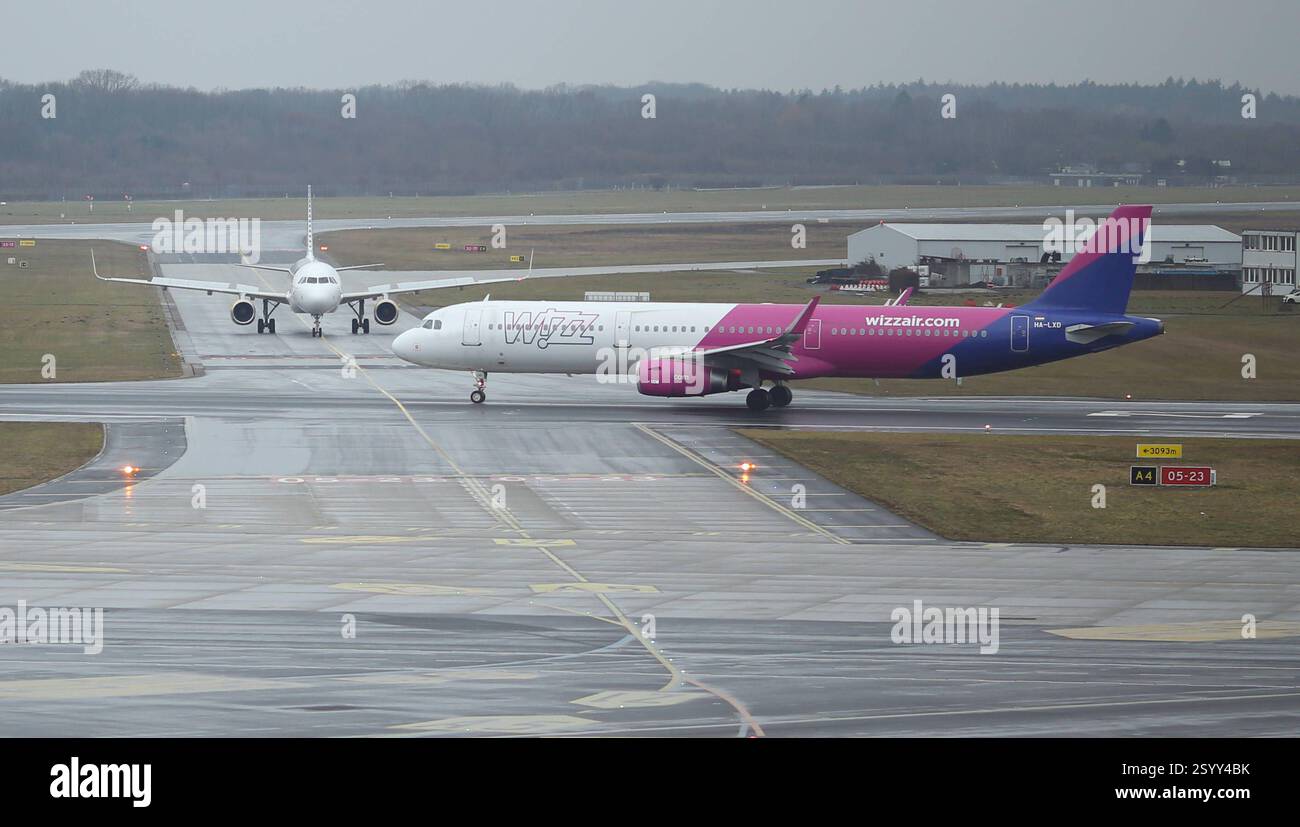 Eine Maschine der Wizz Air steht bei Hamburger Schietwetter auf der Startbahn vom Flughafen Hamburg. Fuhlsbüttel Amburgo *** Un aereo Wizz Air si trova sulla pista dell'aeroporto di Amburgo Fuhlsbüttel ad Hamburgs, maltempo Foto Stock